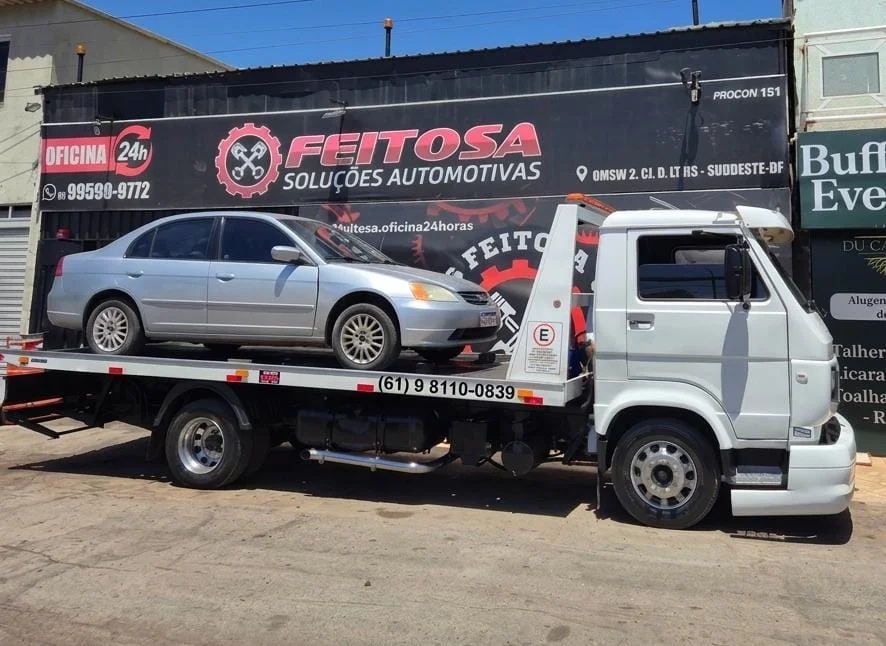 Guincho da Feitosa com veículo na plataforma em frente à oficina